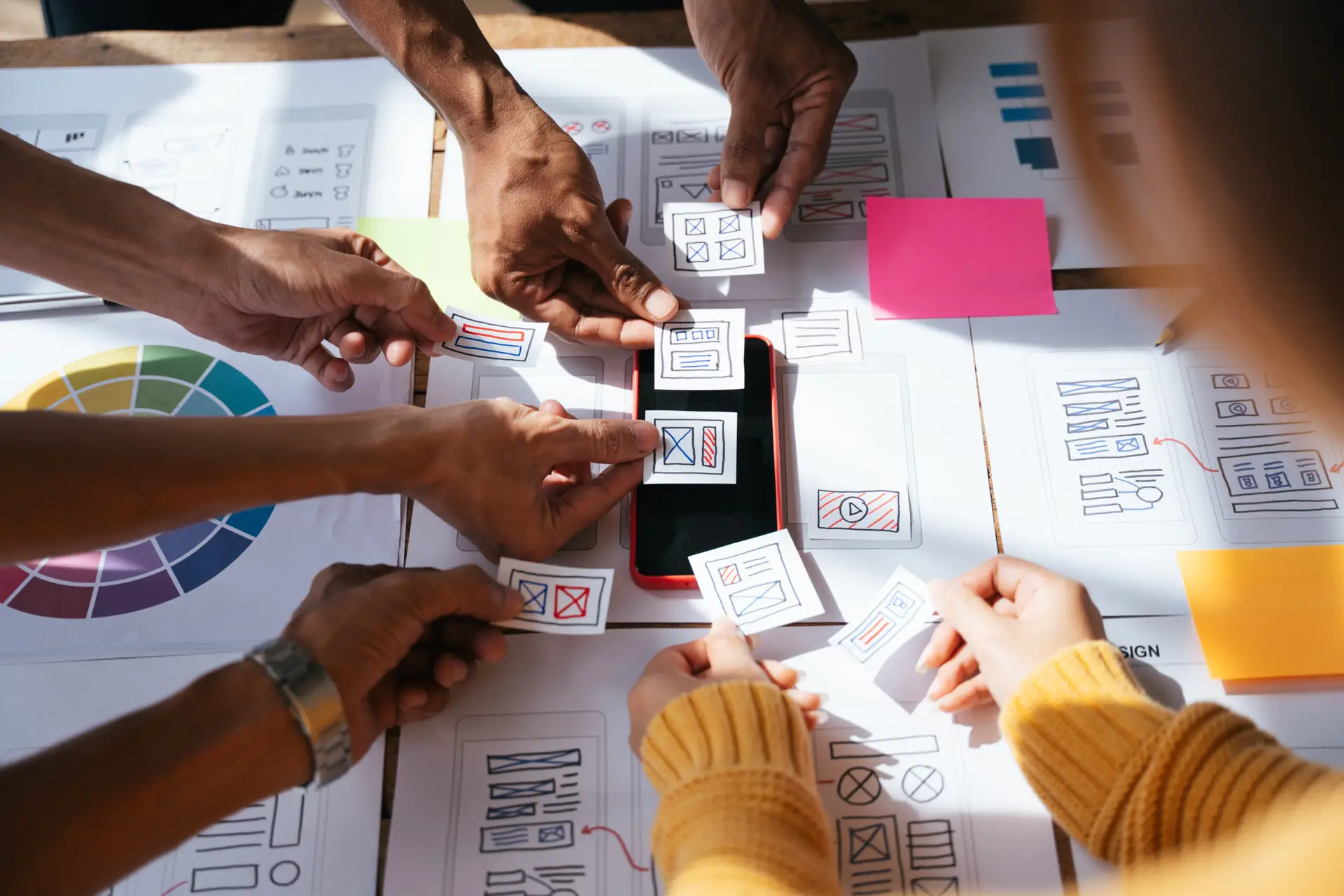 Prestations - Etape de vote lors d'un atelier de conception Ux/Ui. Personnes regroupées autour d'une table en train de voter pour les idées.